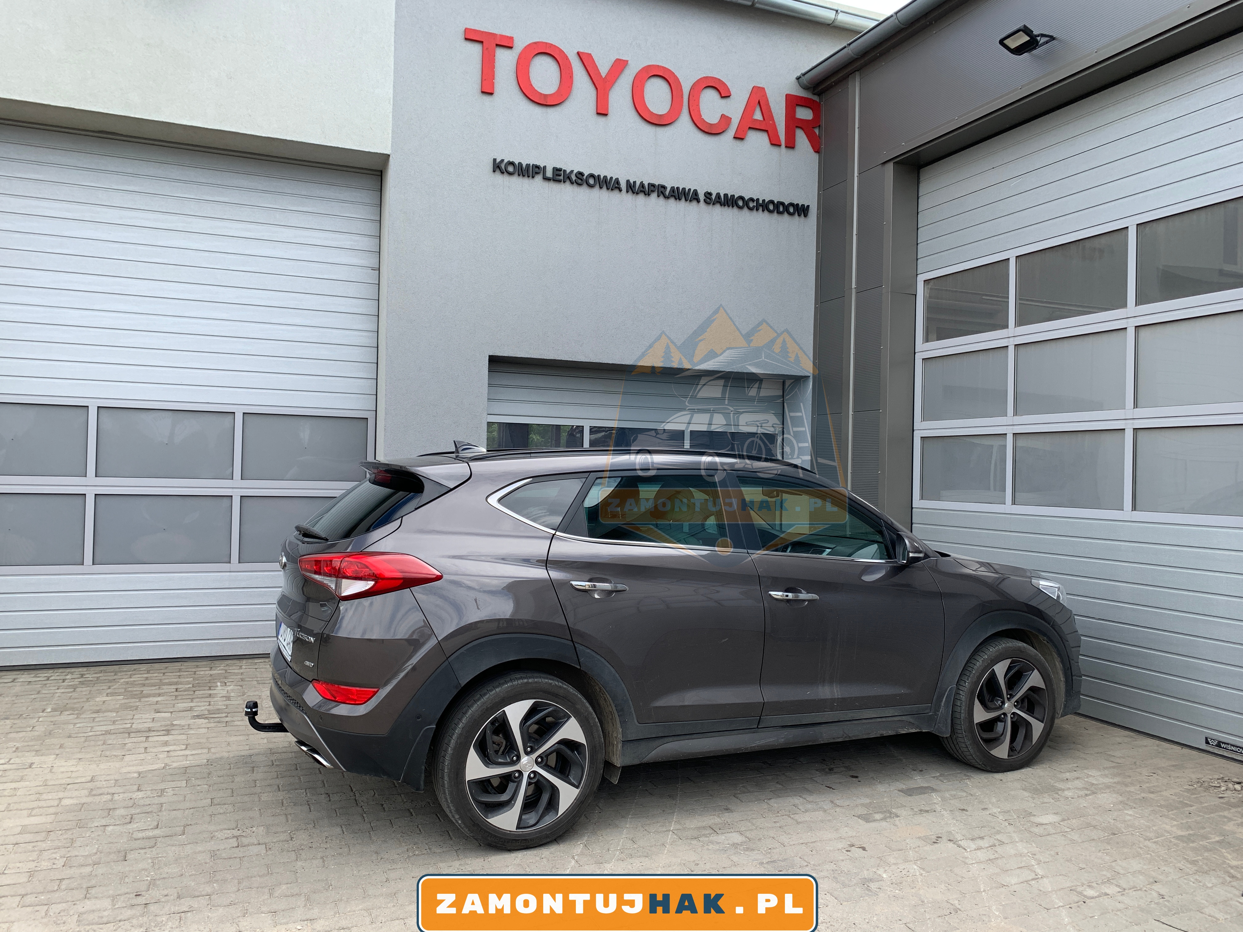 Zdjęcie Hyundaia Tucsona z zamontowanym hakiem holowniczym westfalia A40V, zdjęcie zostało zrobione z prawej strony samochodu na tle serwisu zamontujhak.pl